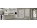 Bright kitchen featuring white cabinets, stainless steel appliances, and a large island with a cooktop at 731 S Missouri Ave, Lakeland, FL 33815