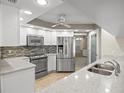 Bright kitchen featuring stainless steel appliances, white cabinetry, and quartz countertops at 7932 Ridge Pointe W Dr, Lakeland, FL 33810