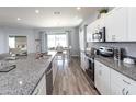 Modern kitchen with granite countertops, stainless steel appliances, and a view into the dining area at 867 Cypress Creek Run, St Cloud, FL 34771