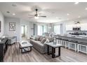 Open-concept living room featuring modern furnishings, hardwood floors, and seamless transition to dining area at 867 Cypress Creek Run, St Cloud, FL 34771