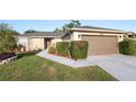 Home exterior boasting a well-kept lawn, established landscaping, and a convenient two-car garage at 8904 Pebblebrooke Dr, Lakeland, FL 33810