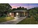 Charming single-story brick home with a covered carport and a well-maintained front yard at dusk at 1017 Fleming Ave, Lakeland, FL 33815