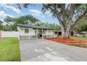 Charming one-story home with a welcoming porch, landscaped front yard, and a large driveway at 113 Patrick Henry Rd, Bartow, FL 33830