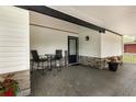 Cozy covered porch with outdoor seating, a 'Welcome' mat, and stylish stone accents on the columns at 113 Patrick Henry Rd, Bartow, FL 33830
