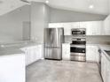 Modern kitchen with white cabinets, stainless steel appliances, and speckled countertops at 1140 Stratton Ave, Groveland, FL 34736