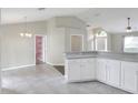 Kitchen area featuring tile floors, white cabinets, and a dining nook next to a doorway to the pantry at 1140 Stratton Ave, Groveland, FL 34736