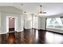 Bright living room featuring hardwood floors, high ceilings, a ceiling fan, and a large window at 1140 Stratton Ave, Groveland, FL 34736