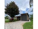 Inviting home exterior featuring a paved driveway, green lawn, and mature trees at 1167 Motorcoach Dr, Polk City, FL 33868