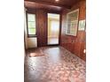 Charming sun room featuring wood paneling, unique tile floors, and windows, offering a bright and inviting space at 1215 E Edgewood Dr, Lakeland, FL 33803