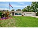 Well-maintained home with a lush green lawn and manicured landscaping around the front at 1235 Lake Point Dr, Lakeland, FL 33813