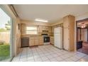 Functional kitchen with white tile floors, essential appliances, and access to the backyard at 1410 Bramblewood Dr, Lakeland, FL 33811