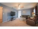 Comfortable living room featuring soft carpet, a leather sofa, and modern entertainment center at 1410 Bramblewood Dr, Lakeland, FL 33811