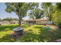 Large, grassy backyard with mature trees, a fire pit, and play equipment, perfect for outdoor entertaining at 1434 Country Ridge Dr, Lakeland, FL 33801