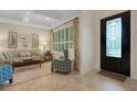 Inviting foyer featuring decorative door, stylish chair, and view of living room with abundant natural light at 1825 Pawnee Trl, Lakeland, FL 33803
