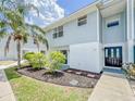 Exterior angle shot of a two-story townhouse featuring light blue siding and landscaped front yard at 222 Carpenters Way # 65, Lakeland, FL 33805