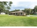 A single story brick house with a large yard, outbuildings, and mature landscaping at 2331 D R Bryant Rd, Lakeland, FL 33810