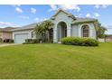 Charming home with manicured lawn, mature landscaping, and a light blue exterior for a serene curb appeal at 2593 Colonel Ford Dr, Lakeland, FL 33813