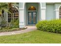 Elegant double doors with decorative glass, framed by manicured landscaping and arched entryway, welcome you home at 2593 Colonel Ford Dr, Lakeland, FL 33813