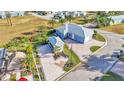 Expansive aerial view of blue house, with a detached garage, surrounded by well-manicured landscaping at 3287 Red Tail Hawk Dr, Polk City, FL 33868