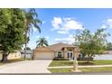 Inviting exterior view of a well-maintained home with a lush lawn, mature trees, and a spacious driveway at 3568 Jade Ln, Mulberry, FL 33860