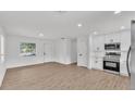 The updated kitchen flows into the living room with light wood floors and stainless appliances at 408 Sycamore Sw St, Fort Meade, FL 33841