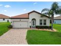 Inviting single-story home with tile roof, paver driveway, and well-maintained landscaping at 4125 Prima Lago Cir, Lakeland, FL 33810