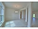 Airy dining area featuring tile floors, crown molding, and a modern chandelier at 4306 Juliana Lake Dr, Auburndale, FL 33823