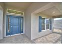 Inviting front porch with stylish blue door, brick floors, and view of home's exterior at 4306 Juliana Lake Dr, Auburndale, FL 33823