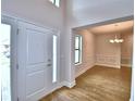 Bright entryway featuring wood-look tile floors, a white door, and views into the dining room at 4312 Juliana Lake Dr, Auburndale, FL 33823