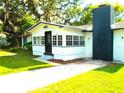 View of the home's entrance, showcasing a bright, window-lined porch and a striking black brick chimney at 4629 Harden Blvd, Lakeland, FL 33813