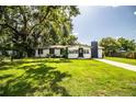 Charming single-story home with white exterior, black trim, chimney, and lush green lawn at 4629 Harden Blvd, Lakeland, FL 33813