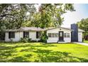 Charming single-story home with white exterior, black trim, chimney, and lush green lawn at 4629 Harden Blvd, Lakeland, FL 33813