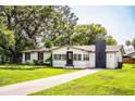 Charming single-story home with white exterior, black trim, chimney, and lush green lawn at 4629 Harden Blvd, Lakeland, FL 33813