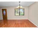 Bright dining area featuring hardwood floors, chandelier, large window, and ample natural light at 5120 Lunn Rd, Lakeland, FL 33811
