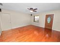Spacious living room with hardwood floors, ceiling fan, neutral paint, and a front entry door at 5120 Lunn Rd, Lakeland, FL 33811