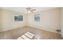 A bedroom with neutral paint, tile flooring, a ceiling fan, and windows at 5140 Alderman Rd, Lakeland, FL 33810