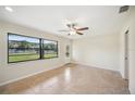 Bright living room with neutral paint, tile flooring, a ceiling fan, and a window at 5140 Alderman Rd, Lakeland, FL 33810