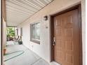 Exterior view of condo unit with stained glass window, brown front door, and outside furniture on patio at 803 Orchid Springs Dr, Winter Haven, FL 33884