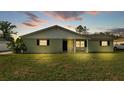 Single-story home at twilight featuring a manicured lawn and inviting front porch seating at 934 Point View Ln, Lakeland, FL 33813
