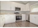 Modern kitchen with granite countertops, stainless steel appliances and white cabinetry at 102 Canterbury Dr, Haines City, FL 33844