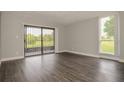 Spacious living room features luxury vinyl plank flooring, sliding door to patio and a picture window at 102 Canterbury Dr, Haines City, FL 33844