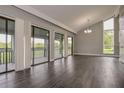 Bright living room with vaulted ceiling, hardwood floors and sliding doors to the balcony at 102 Canterbury Dr, Haines City, FL 33844