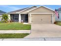 Charming single-story home featuring a two-car garage, screened-in porch, and well-manicured lawn at 1034 Corso Dr, Winter Haven, FL 33884