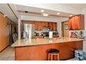 Well lit kitchen with stainless steel appliances, granite counters, a breakfast bar, and wood cabinets at 111 Beverly Dr, Winter Haven, FL 33884