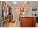 Spacious kitchen with stainless steel appliances, granite counters, tile floors, and wood cabinets at 111 Beverly Dr, Winter Haven, FL 33884