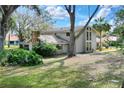 Charming two-story home boasts a large front yard, mature trees, and unique architectural details at 1118 Cypress W Pt, Winter Haven, FL 33884