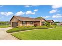 Lovely home featuring a side-entry garage, brick facade, and lush landscaping at 118 Caloosa Dr, Babson Park, FL 33827