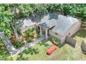Aerial view showcasing the home's well-maintained roof, landscaping, and stone walkway at 1300 Ariana Woods Cir, Auburndale, FL 33823