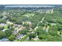 Aerial view of a neighborhood with mature trees and a home with an arrow pointing to it at 1300 Ariana Woods Cir, Auburndale, FL 33823