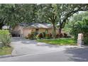 Exterior view of a house with a stone mailbox, well-manicured lawn, and driveway leading to a garage at 1300 Ariana Woods Cir, Auburndale, FL 33823